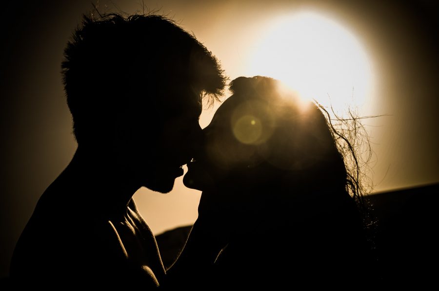 Silhouette of couple kissing against the sunset