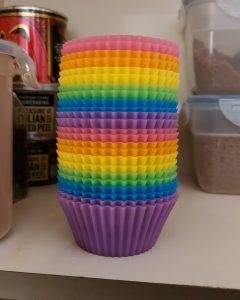 Two sets of rainbow coloured muffin cases stacked as the good lord intended it, in colour-spectrum order